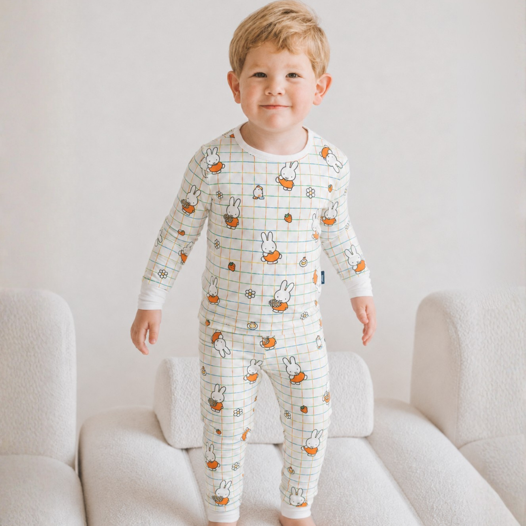 Kind, das das Bambus-Pyjama-Set „Children's Miffy Checkered Bloom“ trägt