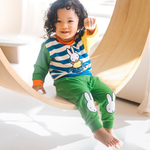 Kind, das das Bambus-Lounge-Set „Move“ in der Farbe Miffy mit einem Sweatshirt mit Fahrradmotiv und einer grünen Jogginghose trägt