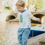 Kind, das das weiße Miffy Kinder-T-Shirt mit grünem Miffy Aufdruck trägt