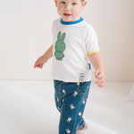 Kind, das das weiße Miffy Kinder-T-Shirt mit grünem Miffy Aufdruck trägt