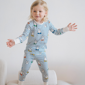 Kind, das das Kinder-Pyjama-Set „Miffy Peek-a-Boo Blue“ aus Bambus trägt